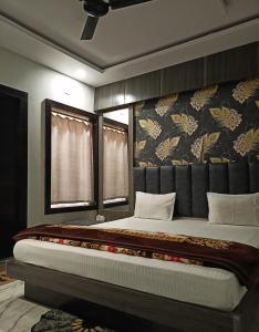 a bedroom with a large bed with a headboard at Shree radhe palace in Datia +28 photos