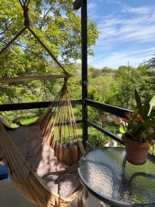 a hammock on a porch with a table and a view at Guest house Me and grandfather-მე და პაპა in Dedoplis Tskaro