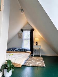 a attic bedroom with a bed and a window at Cozy corner Homestay in Mawphlang