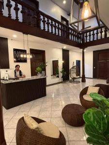 a man standing at a counter in a lobby at Hotel NASS del Sur in Cuenca