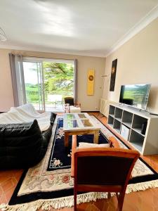 a living room with a couch and a table at Maison familiale champêtre 8 pers in Fontet