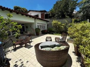 a patio with a large wicker chair and a table at Icaraí Bed & Breakfast in Niterói