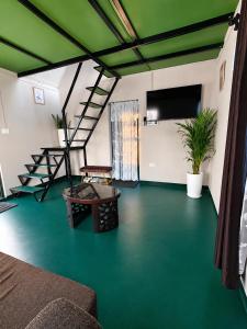 a room with a green floor and stairs in it at Cozy corner Homestay in Mawphlang