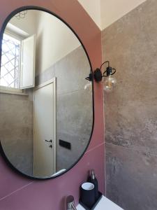 a bathroom with a mirror on a pink wall at Loft Pisacane 27 - Mare e Centro a Piedi in Senigallia +11 photos
