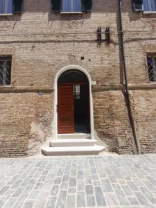 a brick building with a red door and steps at Loft Pisacane 27 - Mare e Centro a Piedi in Senigallia