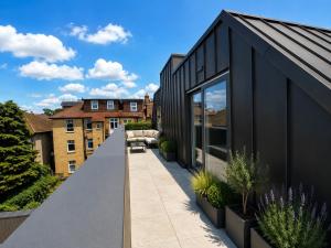 a black house with a balcony with plants at Barnet Luxe 2 Bedroom Penthouse in Barnet