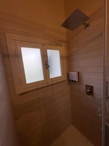 a bathroom with a shower and two windows at Le Magnolie 1924 in Casciana Terme +18 photos