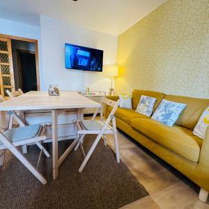 a living room with a yellow couch and a table at Casa Lulù in Cala Gonone