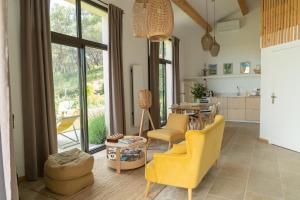 a living room with yellow chairs and a table at La Bergerie du Roy-Chambres D'hôtes- in Rognes