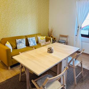 a living room with a table and a yellow couch at Casa Lulù in Cala Gonone +14 photos
