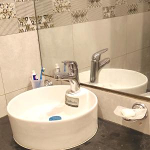a bathroom sink with a faucet and a mirror at Bhurban Nights - Glass Bed Murree Hills View - Lift - 15 Minutes from Murree & Mallroad in Murree +37 photos