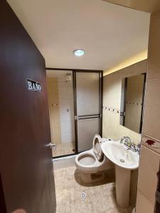 a bathroom with a toilet and a sink at Hostal Brooklyn in Ipiales