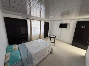 a bedroom with a bed and a flat screen tv at Hostal Brooklyn in Ipiales