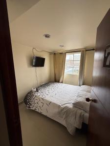 a bedroom with a bed and a window at Hostal Brooklyn in Ipiales
