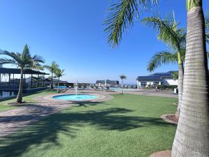 a park with palm trees and a swimming pool at Bohobeach Bliss! in Ballito