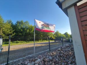 a flag on a fence next to a building at Domki California in Jastrzębia Góra