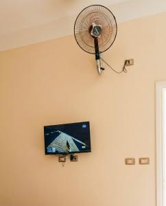 a flat screen tv hanging on a wall with a fan at شاليه العميد chalet in Marsa Matruh