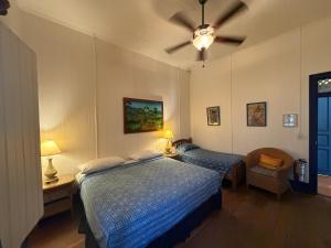 a bedroom with a bed and a ceiling fan at La Posada Azul Boutique Hotel Coco SA in San Juan del Sur +13 photos