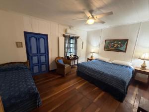 a bedroom with a bed and a blue door at La Posada Azul Boutique Hotel Coco SA in San Juan del Sur