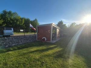 a small shed in a field with the sun shining at Domki California in Jastrzębia Góra
