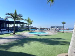 a park with a fountain and palm trees on the beach at The Pearl in Ballito +14 photos