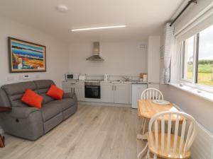 a living room with a couch and a table at Radharc an Hook Estuary Bliss in Duncannon +11 photos