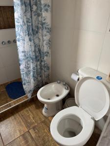 a bathroom with a toilet and a shower curtain at Crisálida Cabañas Villa Yacanto in Villa Yacanto +26 photos