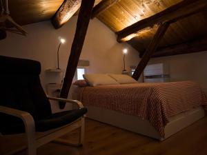 a bedroom with a bed and a chair in a room at La Clarita in Vittorio Veneto