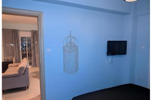 a blue room with a couch and a television at Relaxing home 80m from the sea in Perea