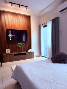 a bedroom with a large bed and a flat screen tv at Hills Residences by JuJu Staycation in Manila