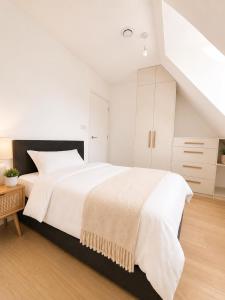a white bedroom with a large white bed and white cabinets at Barnet Luxe 2 Bedroom Penthouse in Barnet