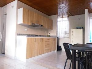 a kitchen with wooden cabinets and a table with chairs at APTO CENTRO DE MELGAR CON PISCINA EN CONJUNTo in Melgar
