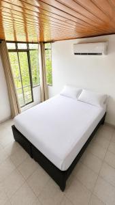 a white bed in a room with windows at APTO CENTRO DE MELGAR CON PISCINA EN CONJUNTo in Melgar +12 photos