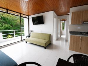 a living room with a couch and a television at APTO CENTRO DE MELGAR CON PISCINA EN CONJUNTo in Melgar