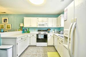 a kitchen with white cabinets and a refrigerator at Nice N Myrtle beach house in Little River