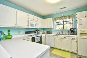 a kitchen with white cabinets and white appliances at Nice N Myrtle beach house in Little River