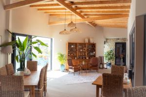 an open living room with a table and chairs at Lagoa Beach House B&B - Breakfast included in Serra do Bouro