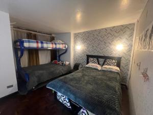 a bedroom with two beds and a bunk bed at Suite Acogedora Centro de Tulcán in Tulcán