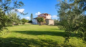 a house on a large grassy field with trees at Villa Rosa dei Venti in Kaštel