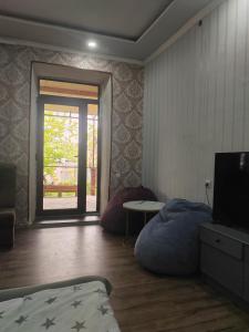 a bedroom with a bed and a tv and a table at STEPANAVAN guesthouse in Stepʼanavan