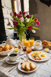 a breakfast table with breakfast foods and coffee and flowers at Castel de Grafeuille in Hautefage