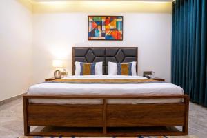 a bedroom with a large bed with blue curtains at Hotel Nexus Cyber Hub Near Rapid Metro & Ambience Mall in Gurgaon