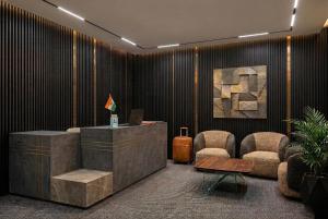 a lobby with a desk and two chairs and a laptop at Hotel Nexus Cyber Hub Near Rapid Metro & Ambience Mall in Gurgaon