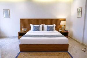 a bedroom with a large bed and two night stands at Hotel Nexus Cyber Hub Near Rapid Metro & Ambience Mall in Gurgaon