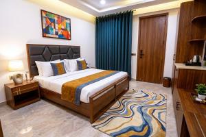 a bedroom with a large bed and a blue curtain at Hotel Nexus Cyber Hub Near Rapid Metro & Ambience Mall in Gurgaon
