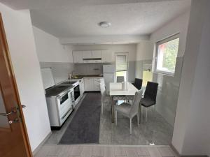 a small kitchen with a table and chairs in it at Apartman HUSEIN in Jajce