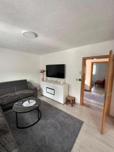 a living room with a couch and a tv at Apartman HUSEIN in Jajce