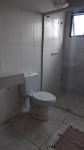 a white bathroom with a toilet and a shower at Pousada dos Cuiabás in Tiradentes