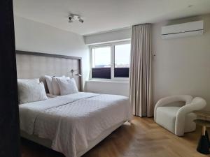 a bedroom with a bed and a window and a chair at Bij de Haven op Urk in Urk
