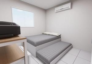 two beds in a room with a window at Hotel JB in Juazeiro do Norte